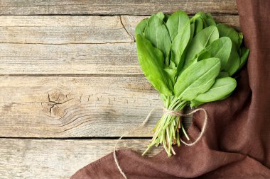 Ahşap masanın üstünde taze yeşil kuş yaprakları var. Metin için boşluk