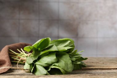 Tahta masanın üzerinde taze yeşil kuş yaprakları var, yakın plan. Metin için boşluk