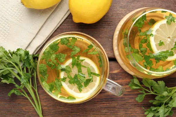 Tahta masaya limon dilimleri konmuş sağlıklı maydanoz çayı. Detoks içeceği