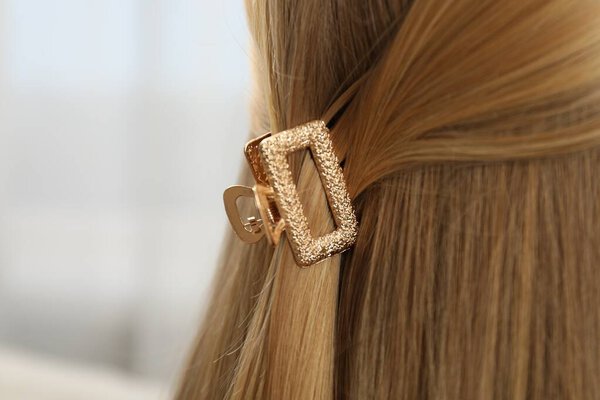 Женщина с красивой заколкой на размытом фоне, крупным планом. Пространство для текста