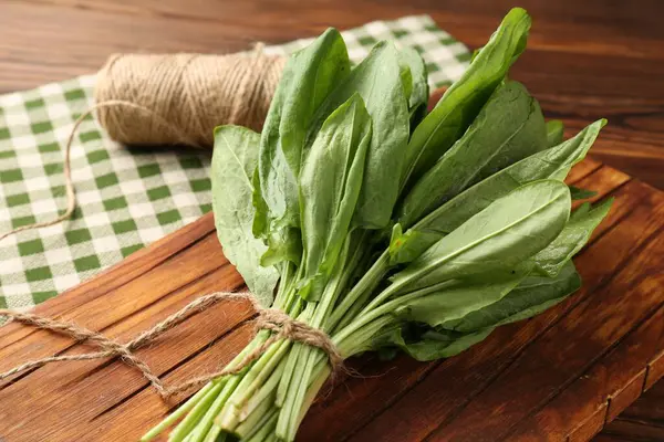 Bir demet taze yeşil kuş yaprağı ve ahşap masa üzerinde sicim, yakın plan