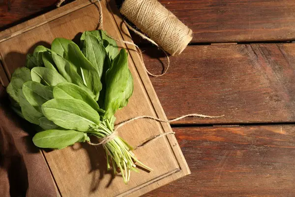 Bir demet taze yeşil doru yaprak ve tahta masa üzerinde sicim düz yatıyordu. Metin için boşluk
