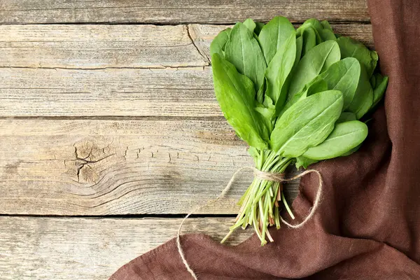 Ahşap masanın üstünde taze yeşil kuş yaprakları var. Metin için boşluk