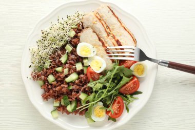 Beyaz ahşap masada kahverengi pirinçli nefis bir salata.