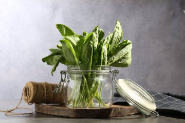 Cam kavanozda taze kuş ve gri masada sicim, yakın plan.