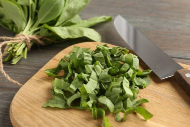 Tahta masada taze kuş yaprakları ve bıçak kes, yakın plan.