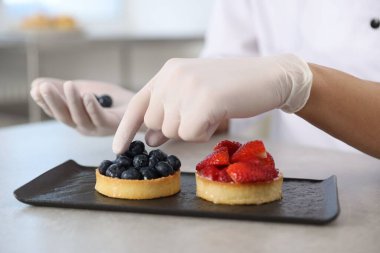 Mutfaktaki gri masada yaban mersinli lezzetli tart, yakın plan.