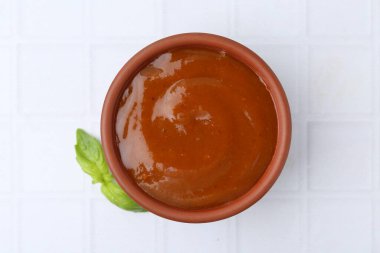 Lezzetli köri sosu ve fesleğen yaprakları beyaz fayanslı masa, üst manzara