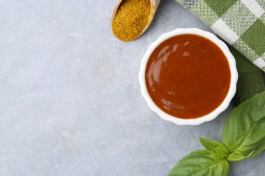 Lezzetli köri sosu, toz ve fesleğen gri masada, düz yerde. Metin için boşluk