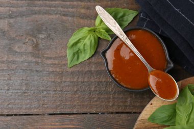 Lezzetli köri sosu ve fesleğen yaprakları ahşap masada, düz yerde. Metin için boşluk