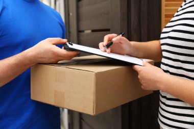 İçerideki kuryeden teslim paketi için alıcı imzası, yakın plan.