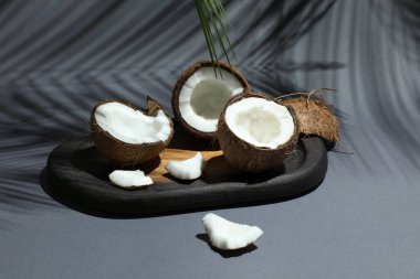 Gri arka planda tropikal palmiyelerin taze hindistan cevizleri ve gölgesi, yakın plan