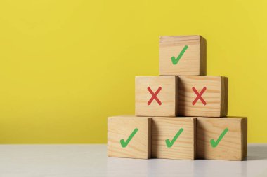 Reddedilmeyi onayla. Sarı arkaplanda işaretli tahta küplerin piramidi