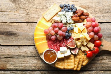 Tahta masa ve üst manzara üzerinde farklı çeşit lezzetli peynir ve diğer atıştırmalıklar. Metin için boşluk