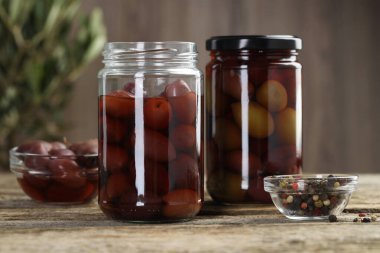 Salamura zeytin ve baharatlar ahşap masada, yakın plan.