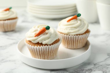 Lezzetli havuçlu kekler beyaz mermer masada, yakın plan.