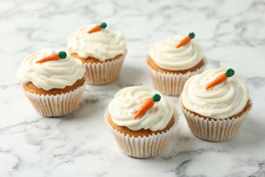 Lezzetli havuçlu kekler beyaz mermer masada, yakın plan.