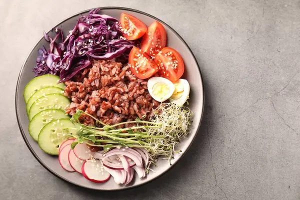 Gri masada kahverengi pirinçli lezzetli bir salata.