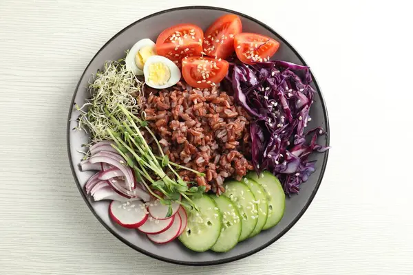 Beyaz ahşap masada kahverengi pirinçli lezzetli bir salata.