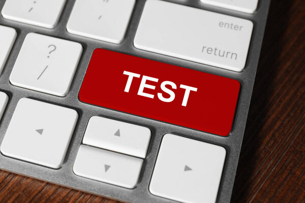 Online test. Computer keyboard with word on red button, closeup