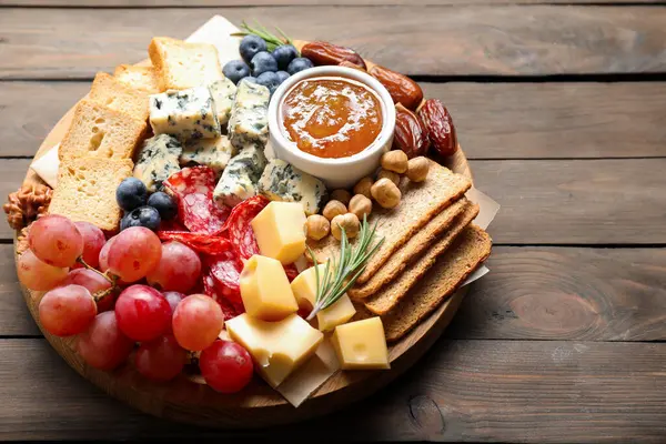 Tahta masadaki farklı lezzetli peynir çeşitleri ve diğer atıştırmalıklar, yakın plan. Metin için boşluk