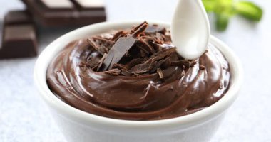 Loş masada kaşıkla kaseden lezzetli çikolatalı pudingi alıp yakın plan çekiyoruz.