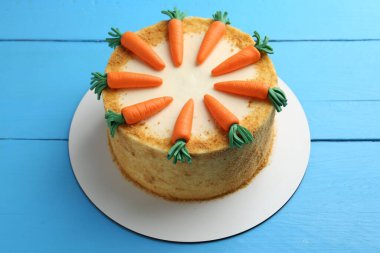 Açık mavi ahşap masada nefis ev yapımı havuçlu kek.