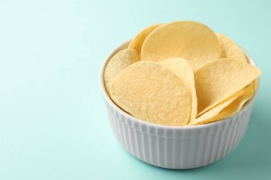 Açık mavi arka planda leziz patates cipsleri, yakın plan. Metin için boşluk