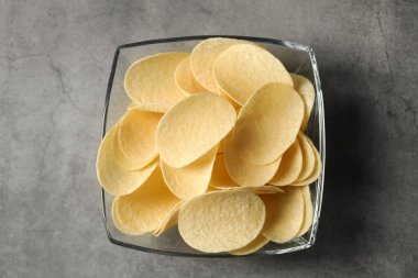 Gri masada leziz patates cipsi, üst manzara.