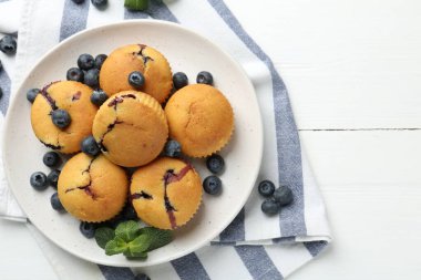 Yaban mersinli lezzetli kekler ve beyaz ahşap masa üzerinde nane şekeri, üst manzara. Metin için boşluk