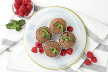 Beyaz ahşap masada ahududu ve nane şekerli nefis çörekler.