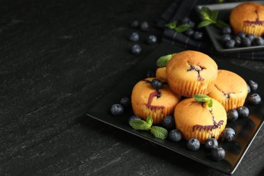 Yaban mersinli lezzetli çörekler ve koyu dokulu masada nane şekeri, yakın plan. Metin için boşluk