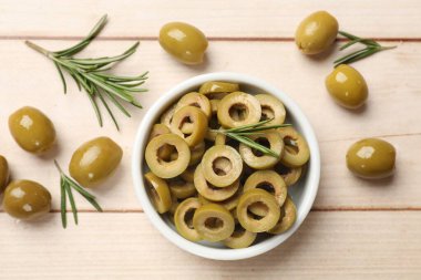 Lezzetli marine edilmiş zeytin halkaları, bütün olanlar ve biberiye açık ahşap masa üzerinde, düz uzanmış