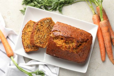 Açık gri masada fındıklı ve sebzeli ev yapımı havuçlu kek.