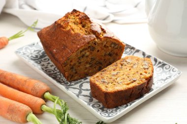 Beyaz ahşap masada fındıklı ve sebzeli ev yapımı havuçlu kek, yakın plan.