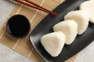 Lezzetli onigiri (Japon pirinç topları) gri masada servis edilir.