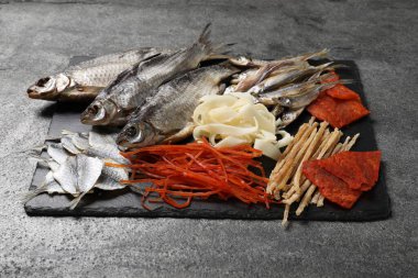 Gri masada birçok farklı kurutulmuş balık atıştırmalıkları var.