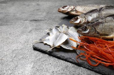 Gri masada bir sürü kurutulmuş balık aperatifi var. Yakın plan. Metin için boşluk