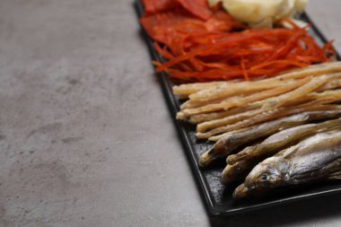 Gri masada bir sürü kurutulmuş balık aperatifi var. Yakın plan. Metin için boşluk