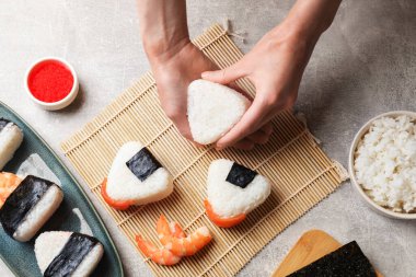 Onigiri yapan kadın (Japon pirinç topları) ışık masasında, üst manzara