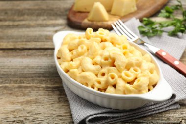 Peynir soslu lezzetli makarna, maydanoz ve ahşap masa çatalı, yakın plan.