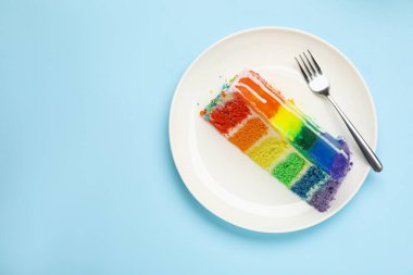 Açık mavi masa üzerinde nefis bir gökkuşağı pastası, üst manzara. Metin için boşluk