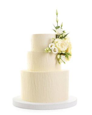 Beyaz çiçeklerle süslenmiş nefis düğün pastası.