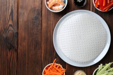 Yenebilir pirinç kağıtları ve ahşap masa üzerindeki malzemeler düz. Metin için boşluk