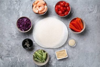 Pirinç kağıt çarşaflar ve açık gri masa üzerindeki farklı malzemeler, düz uzanmış.