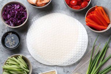 Pirinç kağıt çarşaflar ve açık gri masa üzerindeki farklı malzemeler, düz uzanmış.