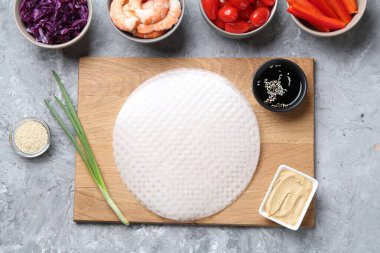 Pirinç kağıt çarşaflar ve açık gri masa üzerindeki farklı malzemeler, düz uzanmış.