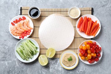 Pirinç kağıt çarşaflar ve açık gri masa üzerindeki farklı malzemeler, düz uzanmış.