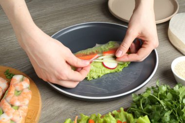 Gri ahşap masada nefis börek yapan kadın, yakın plan.