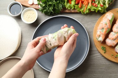 Gri ahşap masada nefis börek yapan bir kadın.